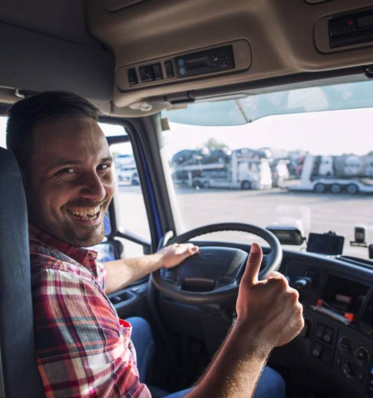 portrait-truck-driver-sitting-his-truck-holding-thumbs-up-1024x683